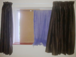 Window obscured by wood, fabric and curtains